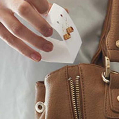 Photo of a person putting a pair of earrings in her handbag